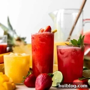 Glasses of agua fresca lined up showing strawberry, watermelon and a pineapple mango.