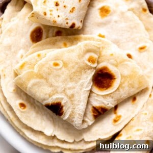 Plate filled with homemade flour tortillas.